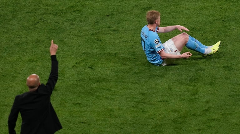 Manchester City's Kevin De Bruyne lies on the pitch following...