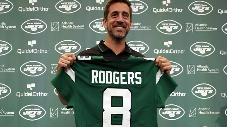 New York Jets quarterback Aaron Rodgers poses with a jersey...