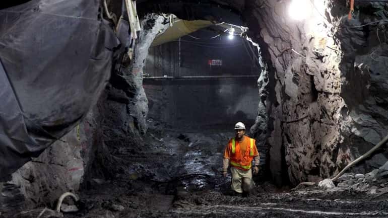 A construction worker walks in a tunnel between the eastbound...