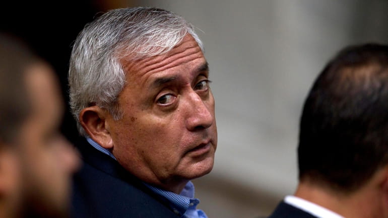 Guatemalan former President Otto Perez Molina looks over his shoulder...