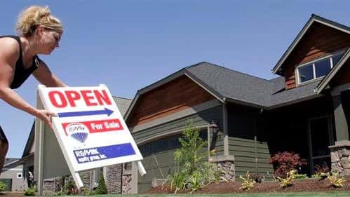 Realtor Sylvia Perry sets out an open sign at a...