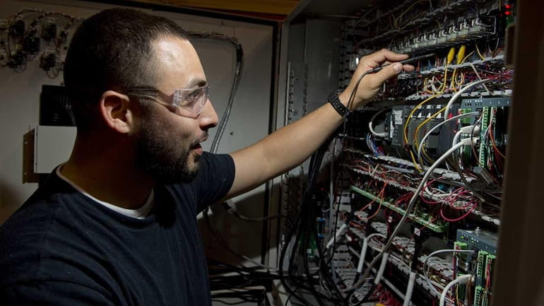 Electrical test technician Julian Pena checks wiring on a component...