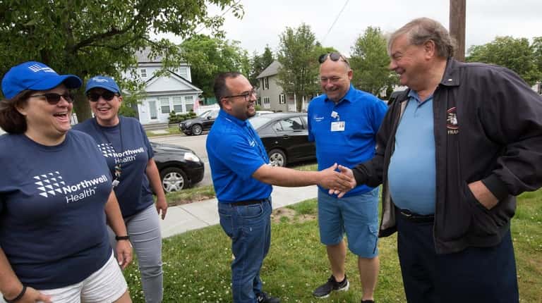 Frank Amalfitano, right, Beacon House president and CEO, greets volunteers...