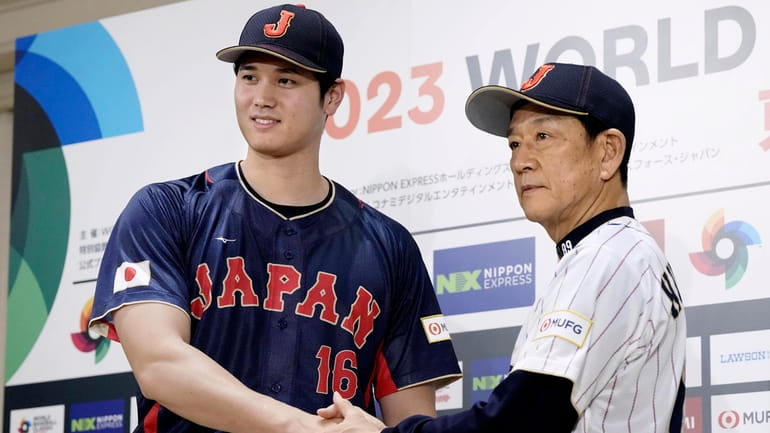 Shohei Ohtani, left, of Los Angeles Angels, shakes hands with...
