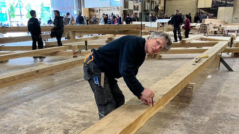 Peter Henrikson, 61, a timber framer from Minnesota, measures a...