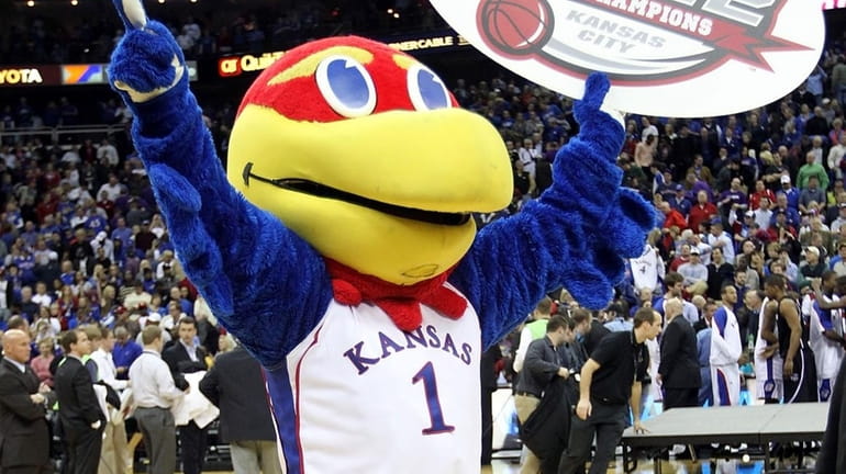 The Kansas Jayhawk mascot celebrates with a championship banner after...