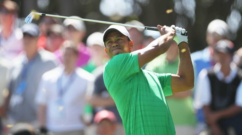 Tiger Woods hits his tee shot on the sixth hole...