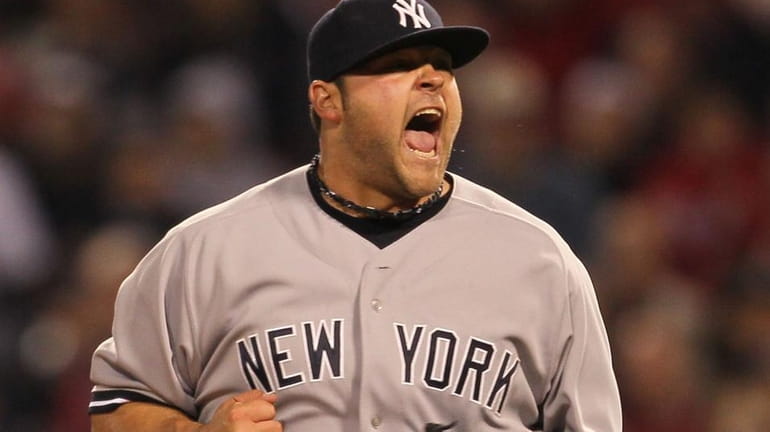 Joba Chamberlain #62 of the New York Yankees reacts after...