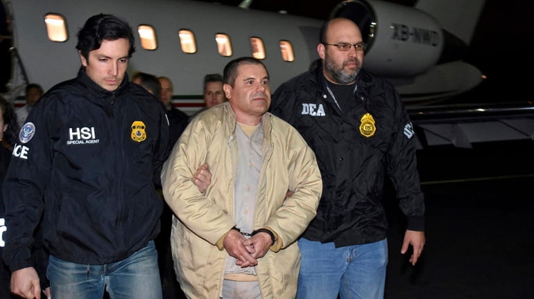 Authorities escort Joaquin "El Chapo" Guzman, center, from a plane...