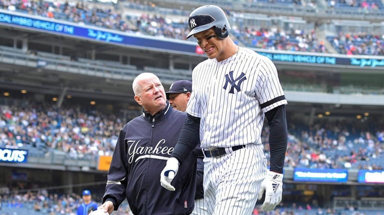 Aaron Judge of the Yankees is checked by the trainer...