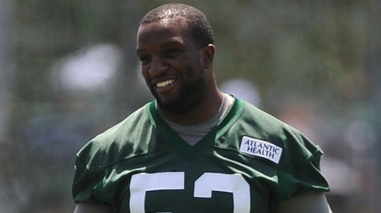 David Harris #52 of New York Jets laughs while stretching...