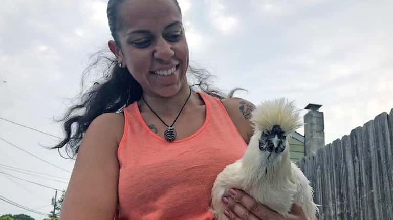 Karin Capellan holds Diva, one of her 15 chickens whom she...
