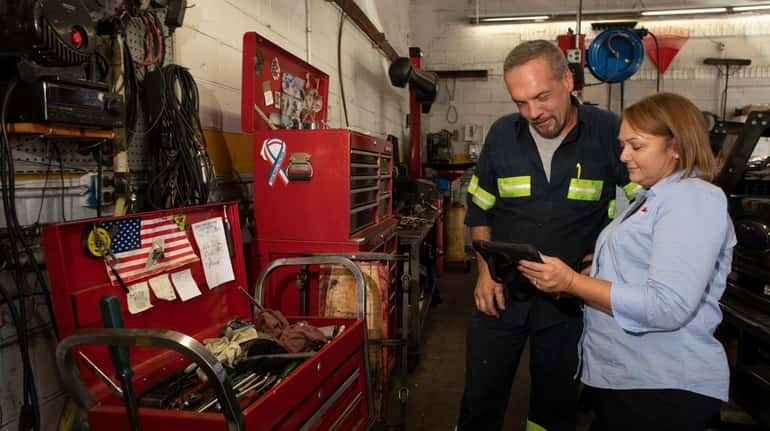 Mechanic Teddy Ott talks with Angel McCabe, president of K&M...