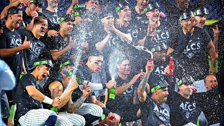 Members off the yankees celebrate with champagne on the field...