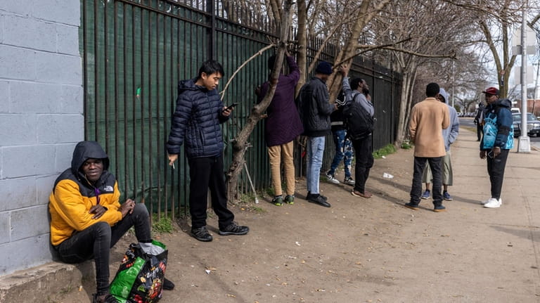 Migrants outside a migrant shelter in Bellerose, Queens, on Friday...