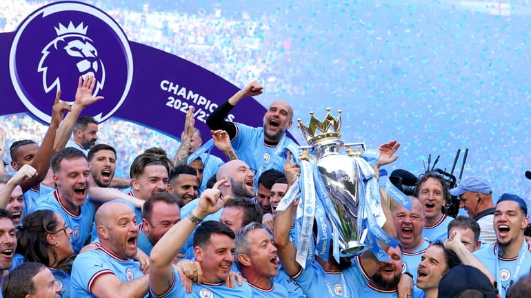 Manchester City players and staff including Pep Guardiola celebrate with...