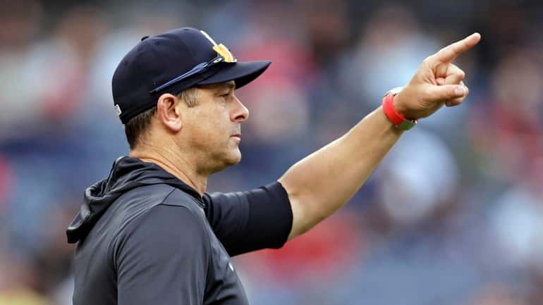 New York Yankees manager Aaron Boone signals for a pitching...
