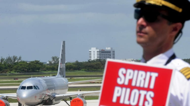 Spirit Airlines pilot Matthew Haklai walks a picket line Sunday...