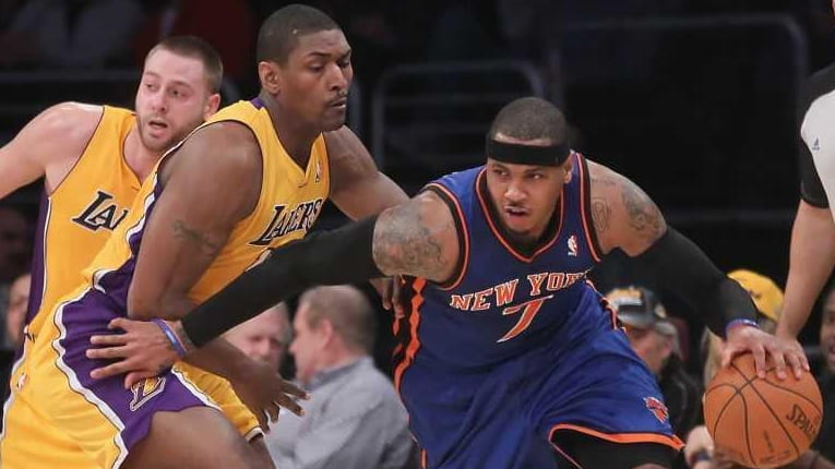 Carmelo Anthony of the New York Knicks drives around Metta...