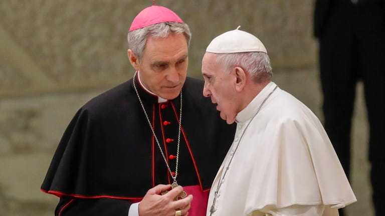 Pope Francis talks with Papal Household Archbishop Georg Gaenswein during...