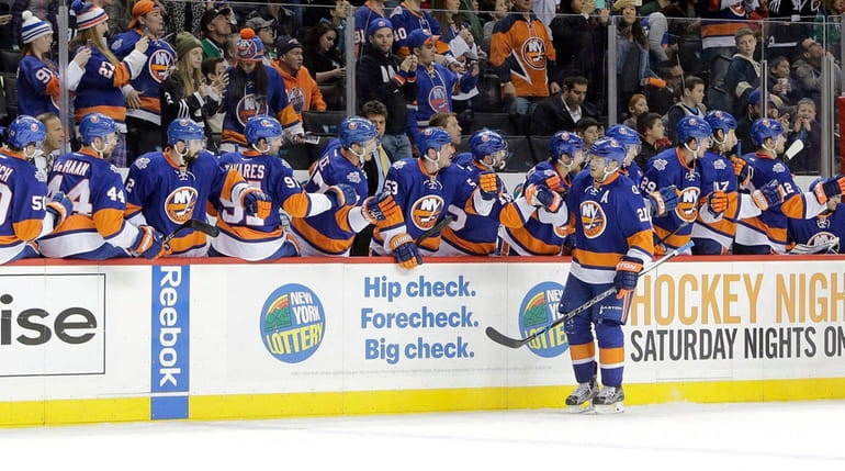 The Islanders bench cheers right wing Kyle Okposo after his...