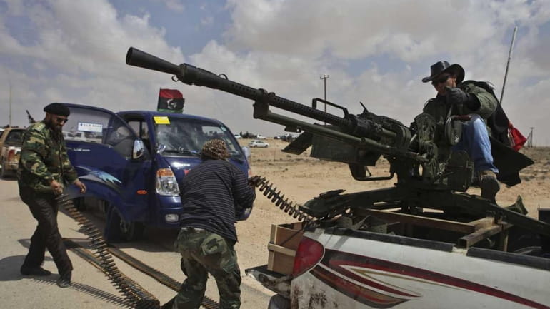 A Libyan rebel, dressed as a cowboy, mans an anti-aircraft...
