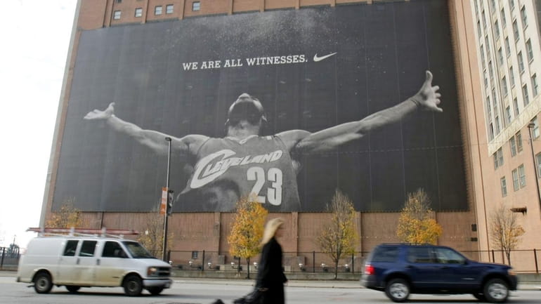 A woman walks past a mural of Cleveland Cavaliers' LeBron...