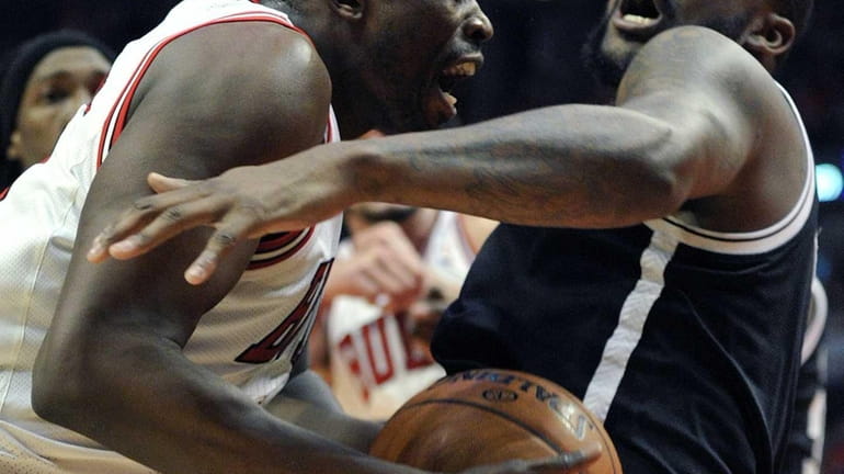Chicago Bulls' Luol Deng, left, drives to the basket against...
