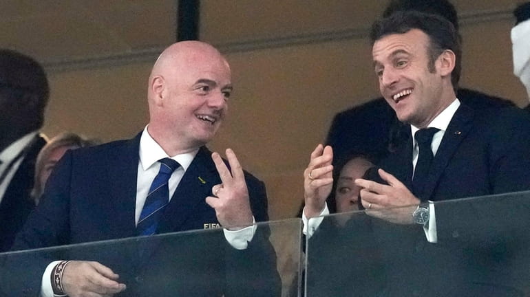 FIFA President Gianni Infantino, left, talks to French President Emmanuel...