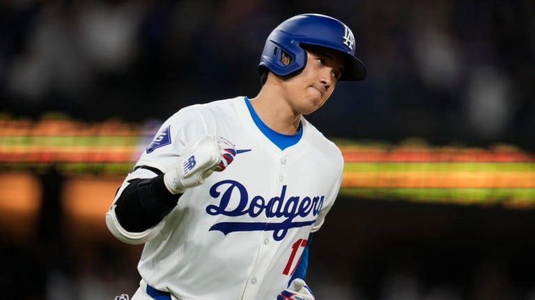 Los Angeles Dodgers designated hitter Shohei Ohtani celebrates as he...