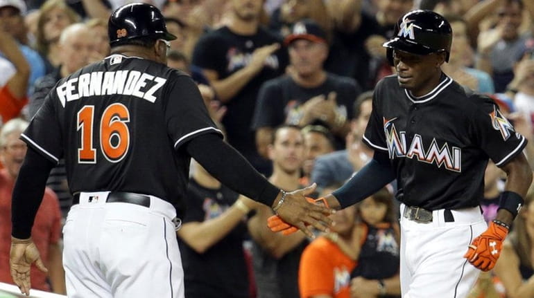 Miami Marlins' Dee Gordon, right, shakes hands with third base...