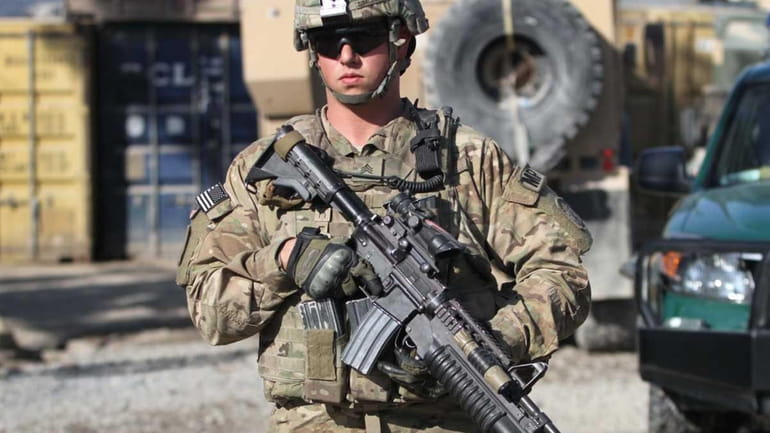 A U.S. soldier walks near the scene of a suicide...