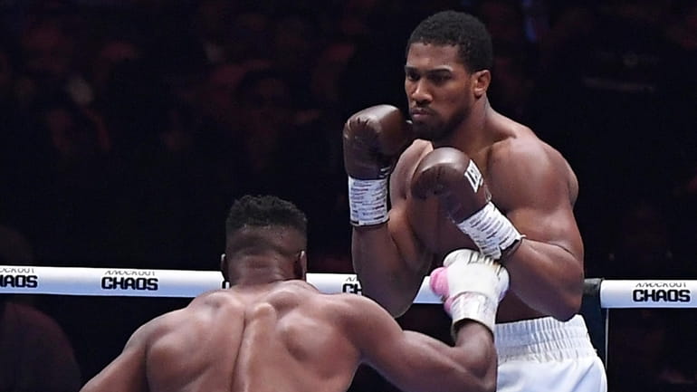 British former world champion Anthony Joshua, right, and MMA fighter...