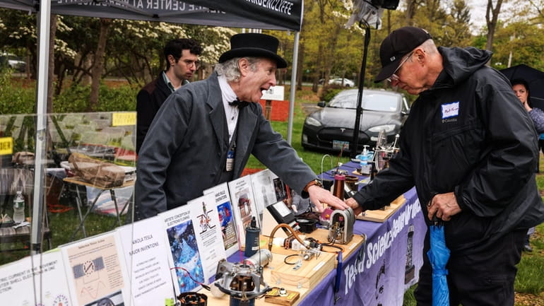 Steven Matza, left, shows Mark Forman a replica of one of Nikola Tesla's...