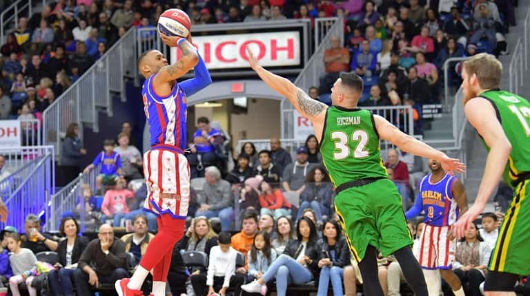 Harlem Globetrotter Chris "Animal" Hyche takes a jump shot against the...