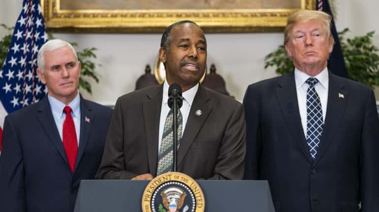Secretary of Housing and Urban Development Ben Carson, flanked by...