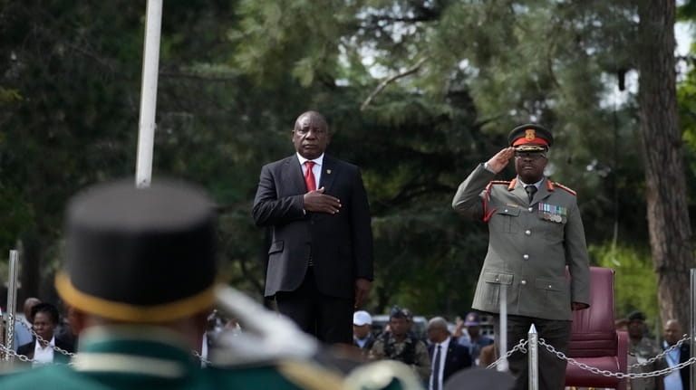 South African President Cyril President, left, takes the salute as...