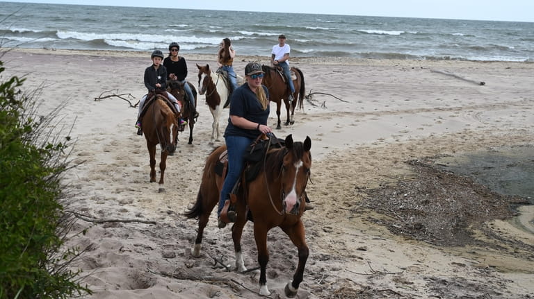 Visitors at Deep Hollow Ranch take a horseback ride in...