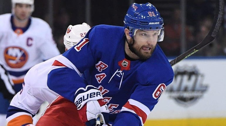 Rangers right wing Rick Nash skates with the puck against...