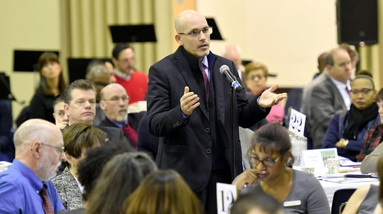 Kenneth Bossert, superintendent of Elwood schools, asks a question at the...