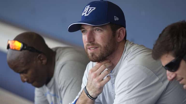 Mets first baseman Ike Davis, right, sits in the dugout...