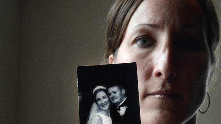 Danielle McDonnell, of Lindenhurst, holds her 2001 wedding photo of...