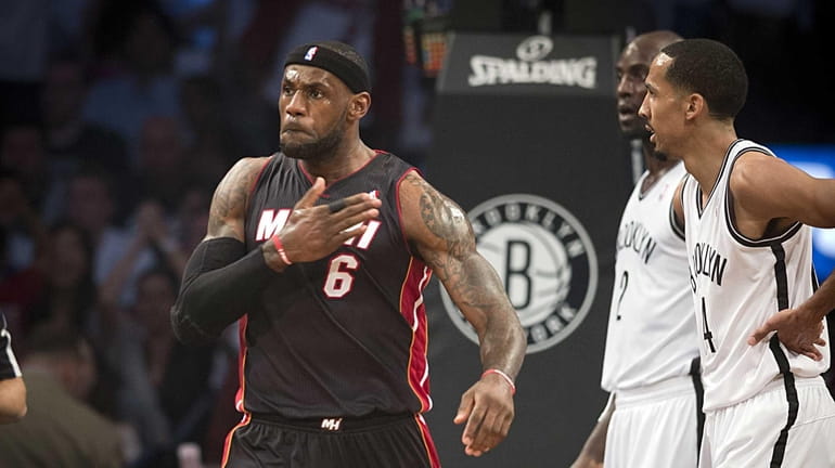 Miami Heat's LeBron James pounds his chest after scoring while...