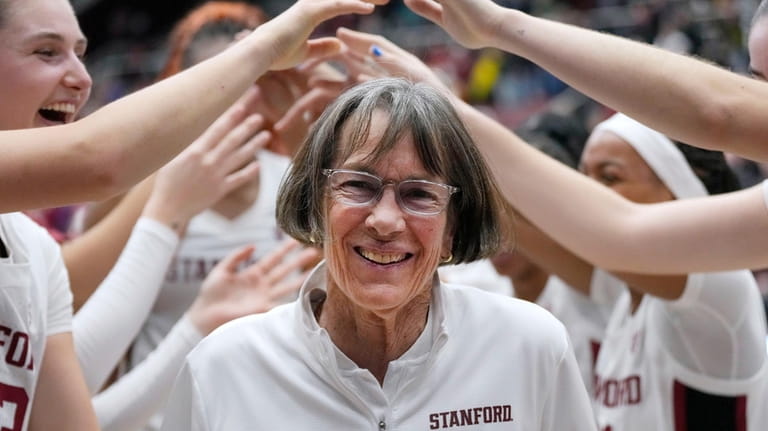 Stanford coach Tara VanDerveer smiles as players celebrate her 1,202nd...