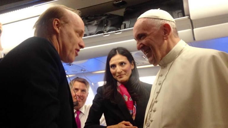 Pope Francis greets journalists including Bart Jones of Newsday, left,...