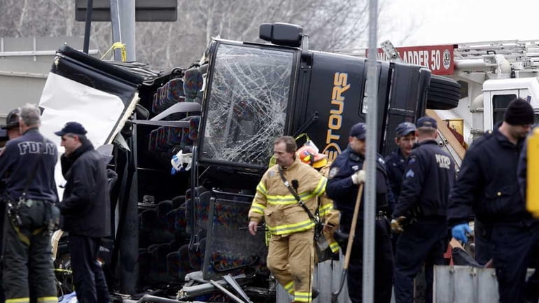 Emergency personnel investigate the scene of a bus crash on...