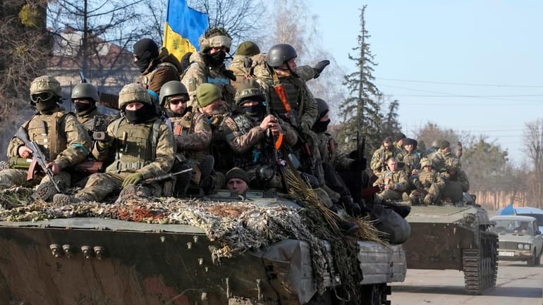 Ukrainian soldiers ride a tank in Trostsyanets, Ukraine, in March...