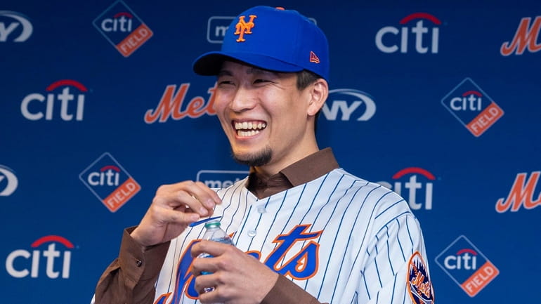 New York Mets pitcher Kodai Senga laughs at an introductory...