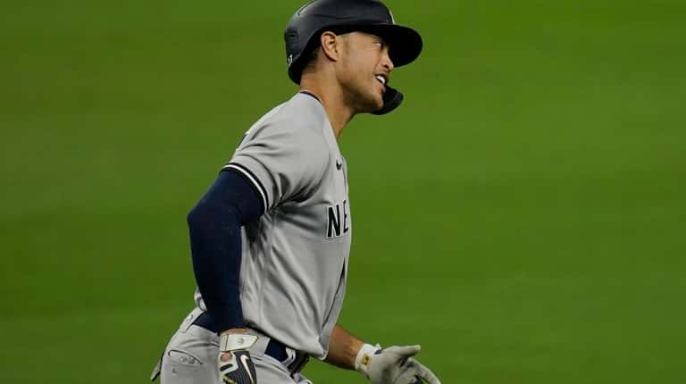 New York Yankees' Giancarlo Stanton rounds the bases after he...