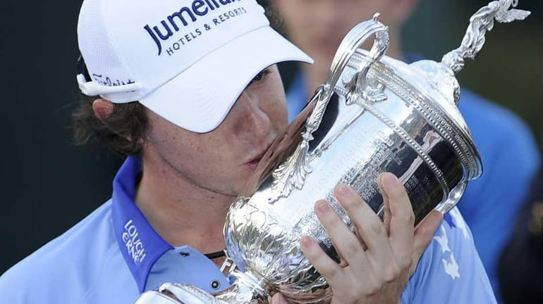 Rory McIlroy, of Northern Ireland, kisses the trophy after winning...